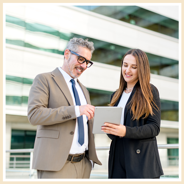 A man and woman looking at an ipad.